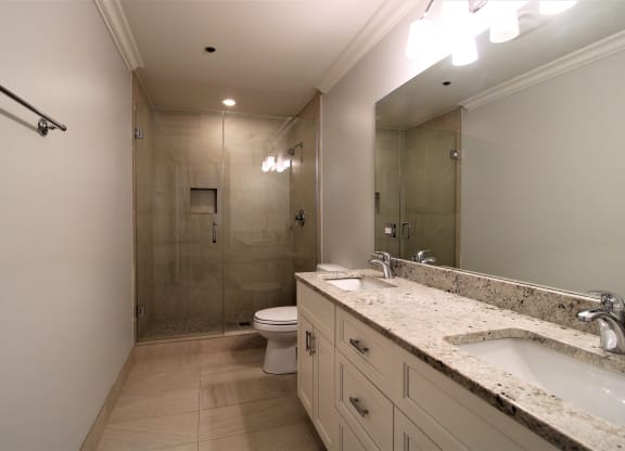 A bathroom with a toilet, sink, and shower.