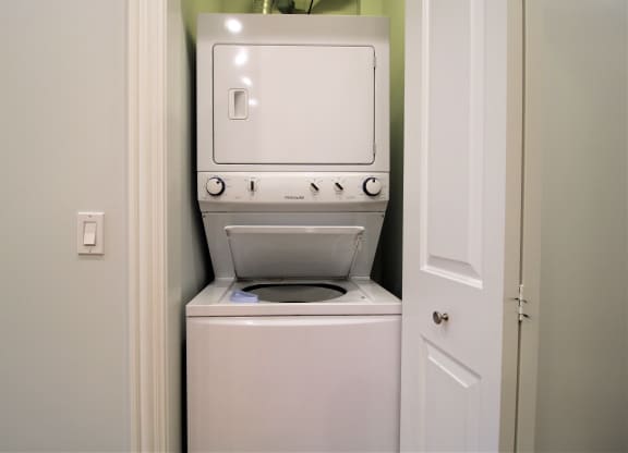 A white washing machine is in a small laundry room.