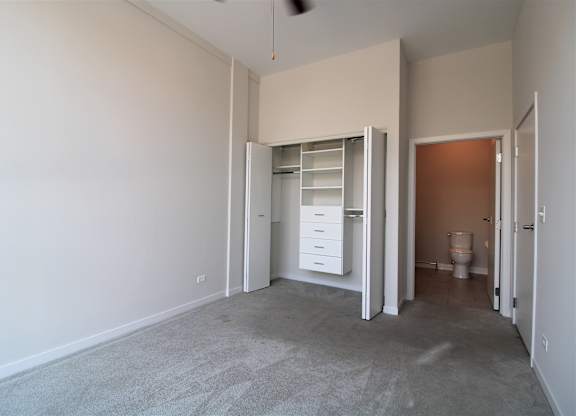 an empty bedroom with a closet and a toilet