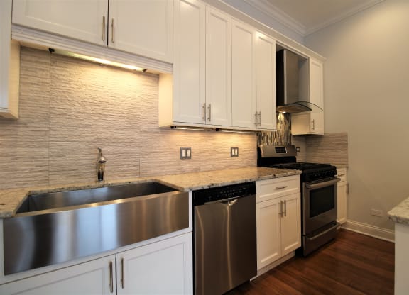 a kitchen with white cabinets and stainless steel appliances