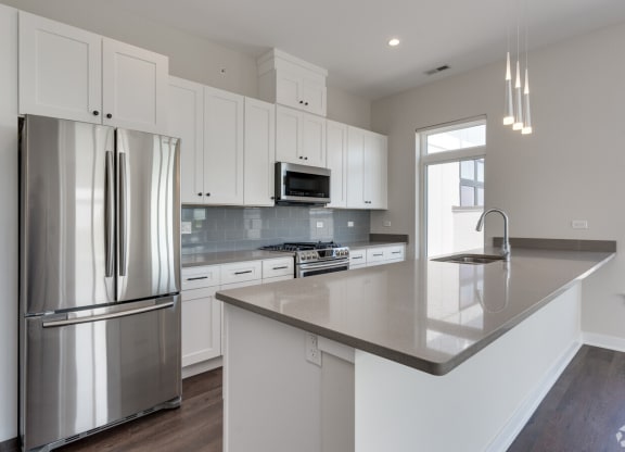 a kitchen with white cabinets and stainless steel appliances