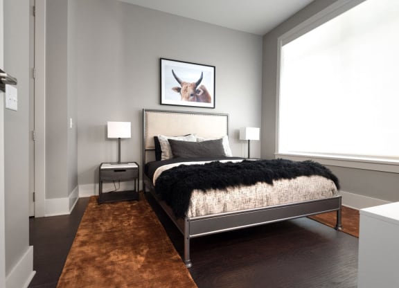 a bedroom with a bed and a picture of a cow on the wall