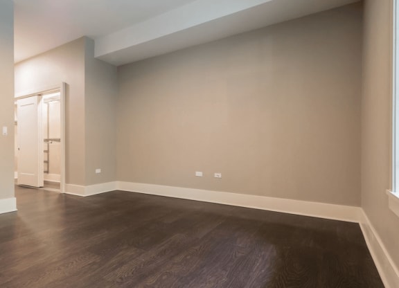 an empty living room with wood floors and white walls