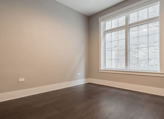 an empty room with wood floors and a window