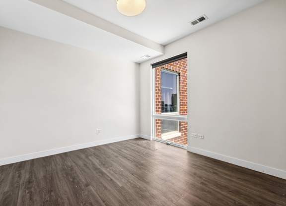 Bedroom at Highpoint Buena Park on Broadway featuring large windows, neutral finishes, and a spacious layout in a modern Buena Park apartment near Montrose Beach in Chicago
