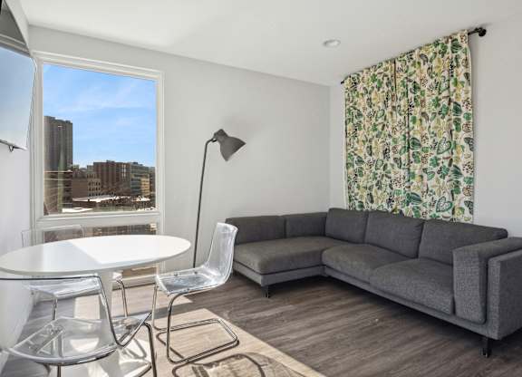Community living and coworking space at Highpoint Buena Park on Broadway featuring lounge seating, individual workstations, and a mounted TV in a modern resident amenity room in Chicago’s Buena Park neighborhood