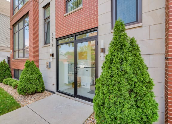 a sidewalk in front of a building with a glass door at Montrose 3634, Chicago