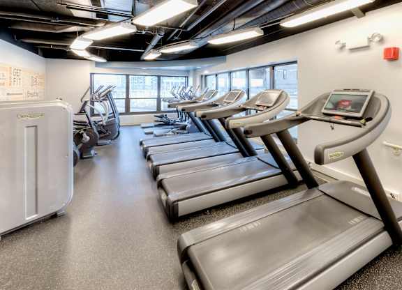 A gym with treadmills and elliptical machines.