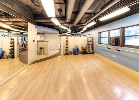 A room with wooden floors and mirrors on the wall.