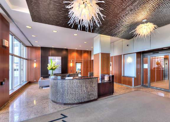 A reception area with a wooden counter and a chandelier hanging from the ceiling.