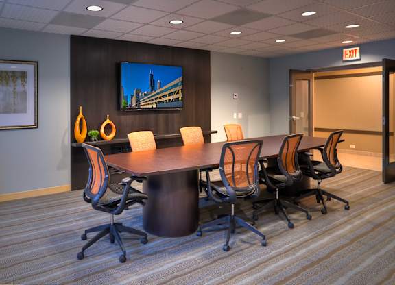 A conference room with a large table and chairs.
