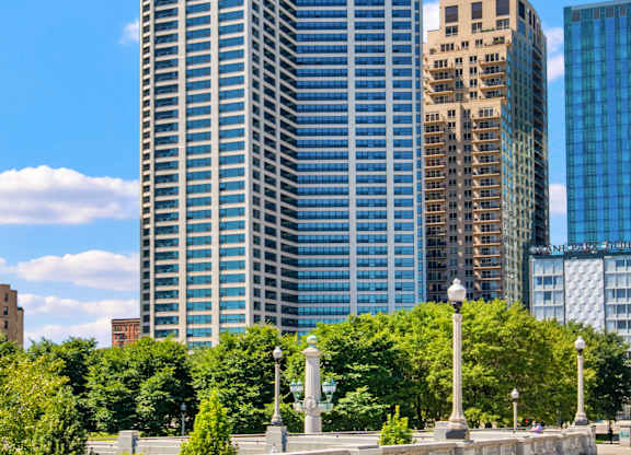 A cityscape with a large building in the middle and a smaller one to the right.