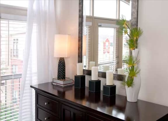 a table with candles and a mirror in front of a window