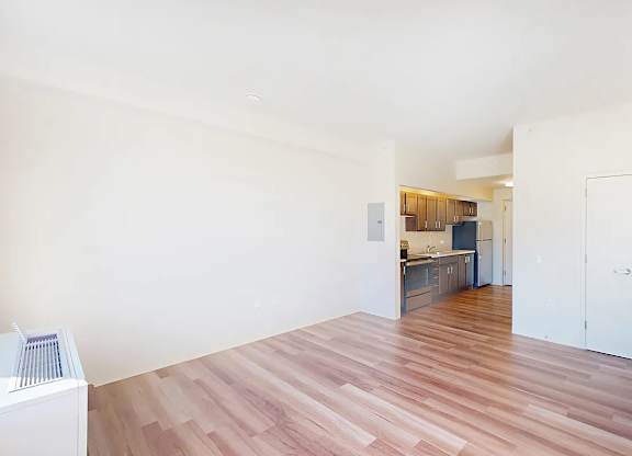 A room with wooden flooring and white walls.