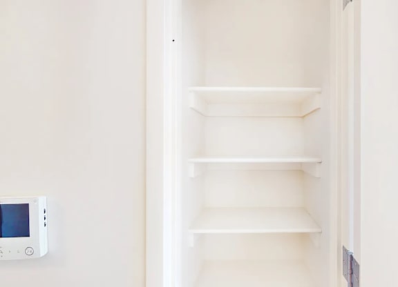 A white refrigerator with an empty shelf and a digital display on the left side.
