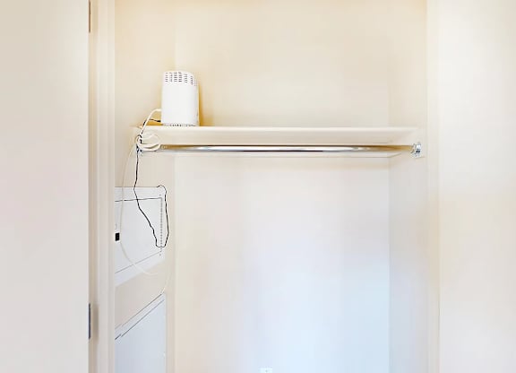 A white shelf with a fan on it.