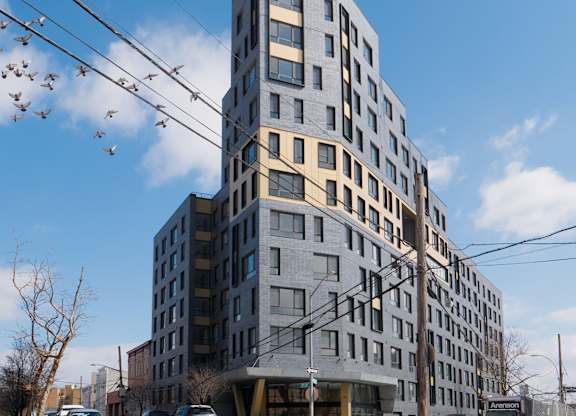 A large grey building with many windows is in the foreground.