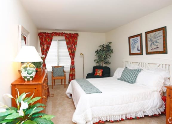 a bedroom with a bed and a table and a window