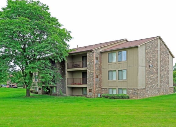 a building with a green lawn and a tree