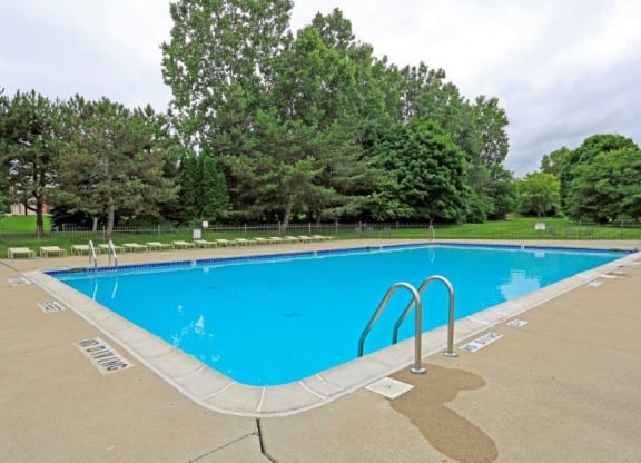 a swimming pool with trees in the background