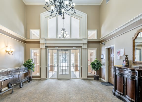 a large hallway with a chandelier and a glass door