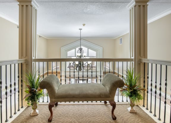 a large balcony with a couch and two potted plants
