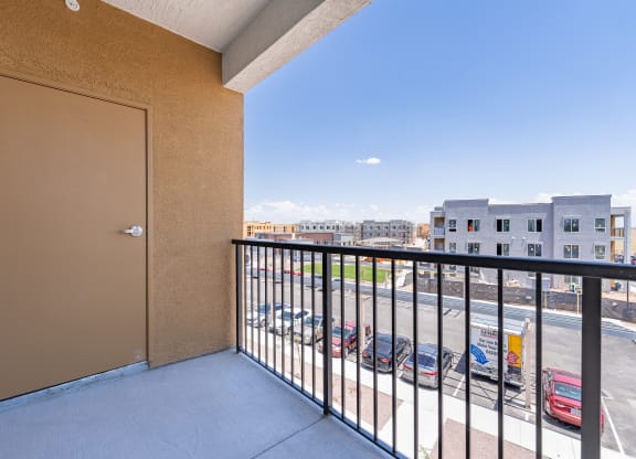 a balcony with a view of a parking lot and buildings