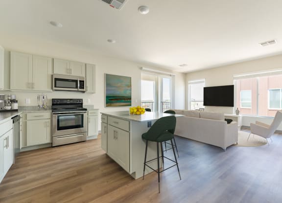 a kitchen and living room with hardwood floors and white cabinets