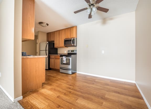 a kitchen and living room with hardwood floors and a ceiling fan at Heritage Hills Apartments, Minnesota