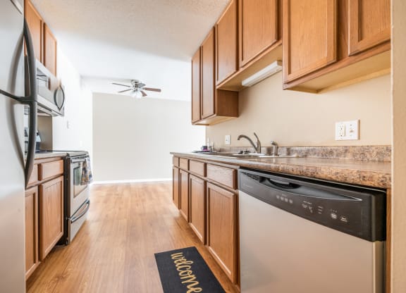 a kitchen with wooden cabinets and stainless steel appliances at Heritage Hills Apartments, Bloomington, MN