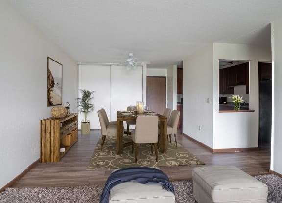 a dining room and living room with white walls and wood floors