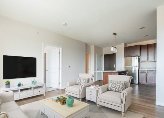 a living room with white furniture and a flat screen tv