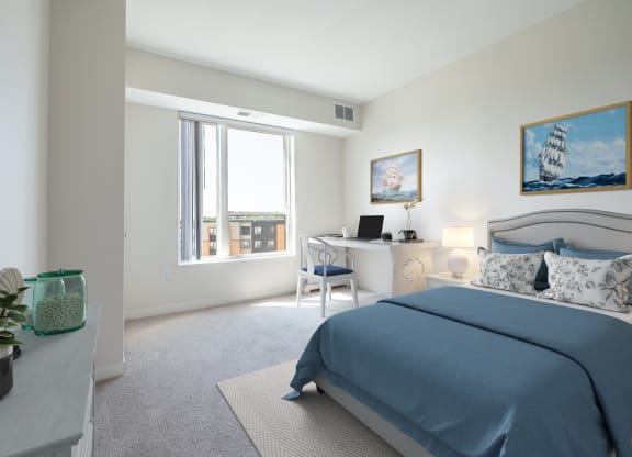 a bedroom with a bed and a desk with a computer