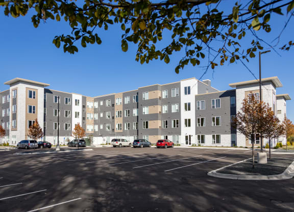a large apartment building with cars parked in a parking lot