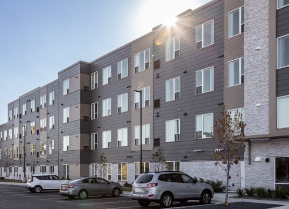 a large apartment building with cars parked in front of it