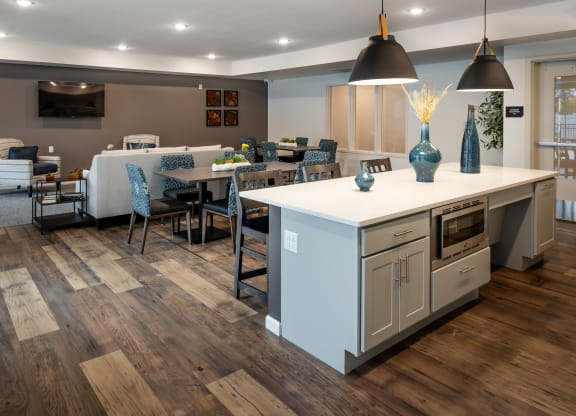 a kitchen with a large island and a dining room with a table and chairs