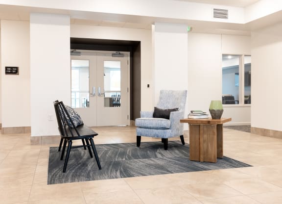 a lobby with chairs and a table in front of a door