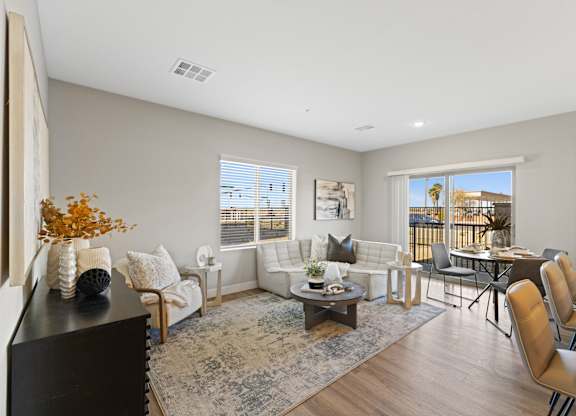 a living room with couches and chairs and a table and a balcony at Agave House Apartments, Casa Grande, 85122