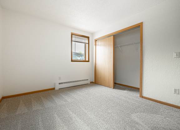 an empty room with a closet and a window at Ames Lake Neighborhood Apartments, St. Paul, 55106