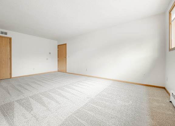 the living room of a house with a white floor and a wooden door at Ames Lake Neighborhood Apartments, St. Paul, 55106