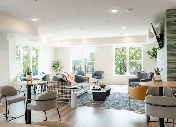 A living room with a couch, chairs, and a television.