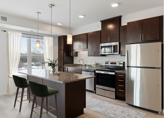 a kitchen with stainless steel appliances and a marble counter top