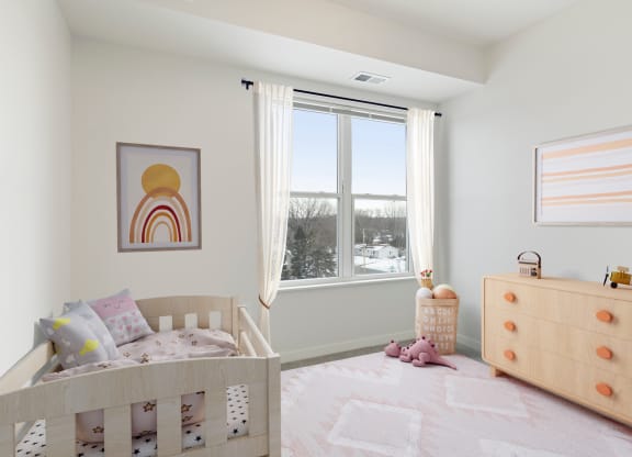 a bedroom with a crib and a dresser and a window