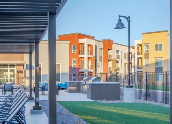 a park with benches and a lawn in front of some apartments