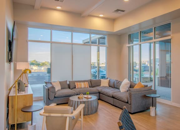 a living room with couches and a coffee table and large windows