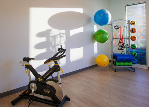 a gym with an exercise bike and balloons on the wall