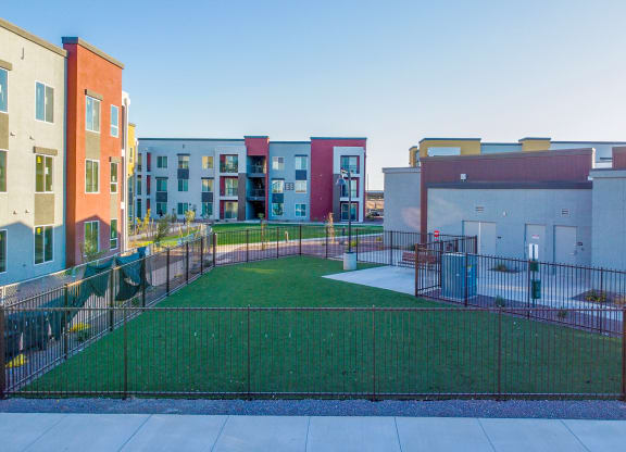 a fenced in yard in front of some apartment buildings