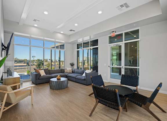 A living room with a grey couch, a black chair and a wooden table at Copa Flats Apartments, Arizona, 85138