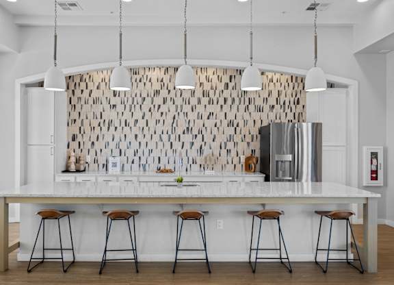 A kitchen with a white counter and bar stools at Copa Flats Apartments, Maricopa, Arizona