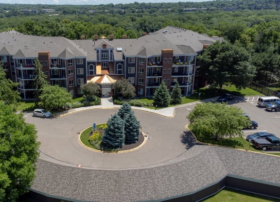 an aerial view of a large building with trees and a fountain